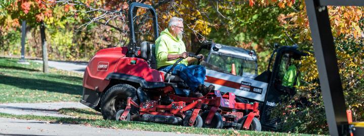 Facilities mowing campus lawn.